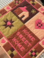 Quilted wall hanging with text 'Home Sweet Home'